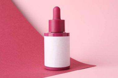 Pembe arka planda bir şişe cilt bakımı ürünü