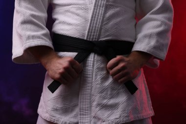 Kimonolu karate dövüşçüsü. Renkli ışıklar ve duman, yakın plan.