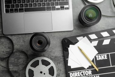Gri desenli masa üzerinde film makarası, film makarası ve kamera lensi ile düz kompozisyon