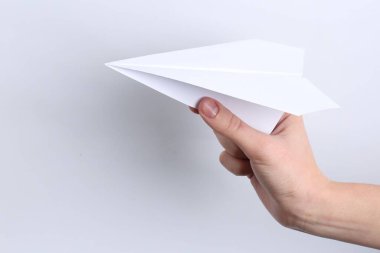 Beyaz arka planda el yapımı kağıt uçaklı kadın, yakın plan.