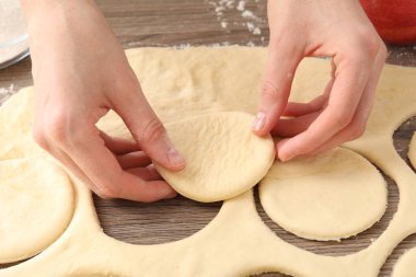 Ahşap masada pirozhki yapan kadın, yakın plan.