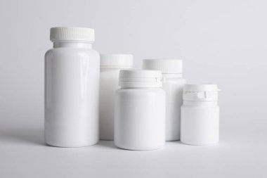 Beyaz arka planda birçok plastik tıbbi şişe