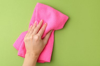Yeşil arka planda temiz, pembe, mikrofiber kumaşlı bir kadın. Metin için boşluk