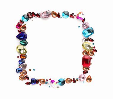 Beyaz arka planda, düz zeminde farklı parlak değerli taşların çerçevesi. Metin için boşluk