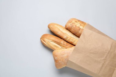 Beyaz arka planda taze baget ve ciabatta ile kağıt torba, üst manzara. Metin için boşluk