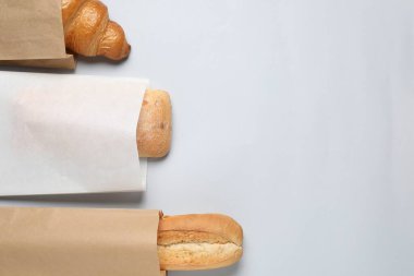 Beyaz arka planda taze hamur işleriyle dolu kağıt torbalar. Metin için boşluk