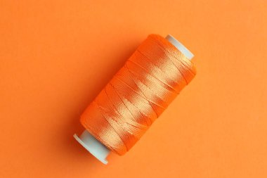 Turuncu arka planda parlak dikiş ipliği, üst görünüm