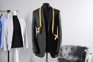 Ceketli erkek manken ve terzi dükkanında mezura.