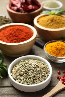 Ahşap masada farklı aromatik baharatlar, yakın plan.