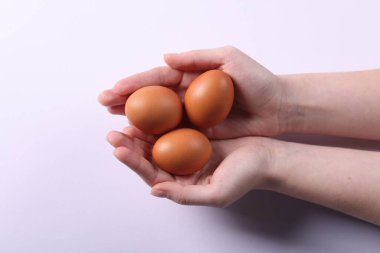 Hafif arka planda çiğ yumurtası olan kadın, yakın plan.