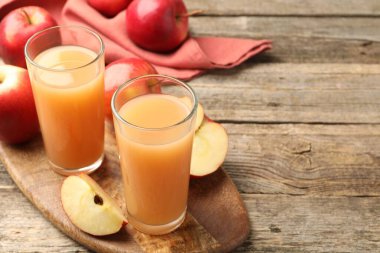 Bardakta lezzetli elma suyu ve ahşap masada taze meyveler, yakın plan. Metin için boşluk