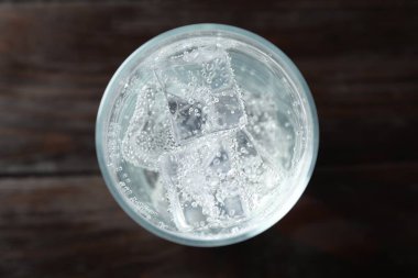 Soda tazeleniyor, cam küpler ve ahşap masa, üst manzara.