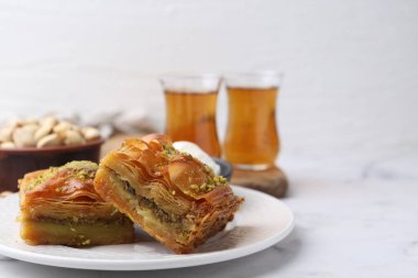 Beyaz mermer masada ezilmiş fındıklı ve dondurmalı enfes baklava, yakın plan. Metin için boşluk
