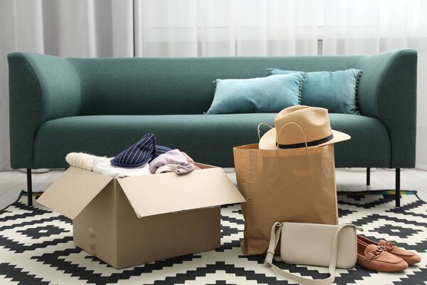 Used clothes, paper bag and box on floor indoors