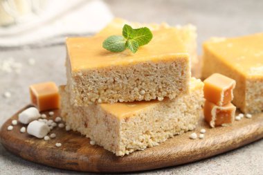 Lezzetli puflanmış pirinç çubukları, şekerler ve gri desenli masada nane şekeri, yakın plan.