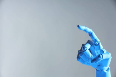 Yapay zeka. Robot el gri arkaplanda bir şeye işaret ediyor, metin için boşluk