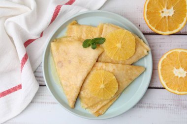 Lezzetli Krep Suzette ve portakallar beyaz ahşap masa, üst manzara