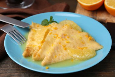 Tahta masada lezzetli krepli Suzette tabağı, yakın plan.