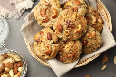 Hasır sepetin içinde fındıklı kurabiyeler gri masada, üst manzara