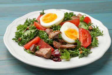 Açık mavi ahşap masada nefis taze ton balığı salatası, yakın plan.