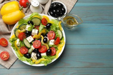 Lezzetli taze Yunan salatası ve açık mavi ahşap masa üzerindeki malzemeler. Metin için boşluk
