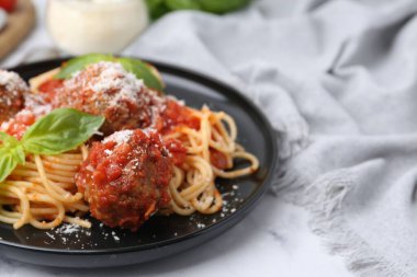 Köfteli makarna, fesleğen ve peynir beyaz masada, yakın plan.