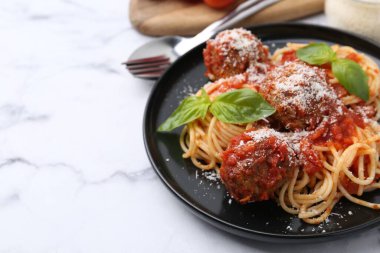 Köfteli lezzetli makarna, fesleğen ve peynir beyaz mermer masada, yakın plan. Metin için boşluk