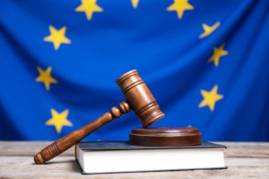 Judge's gavel on wooden table against European Union flag, closeup clipart