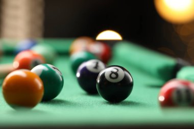 Birçok renkli bilardo topu yeşil masada, kapalı alanda, yakın planda.