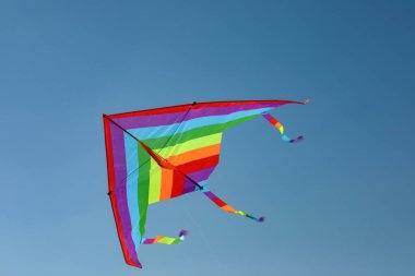 Mavi gökyüzünde uçan renkli bir uçurtma