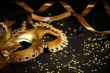 Güzel bir karnaval maskesi, koyu arkaplanda kurdele ve konfeti, yakın plan.