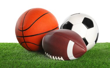 Beyaza izole edilmiş yapay çimenlerdeki farklı toplar. Spor malzemeleri.