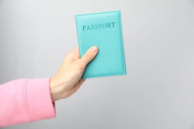 Gri arka planda pasaportu olan kadın, yakın plan.