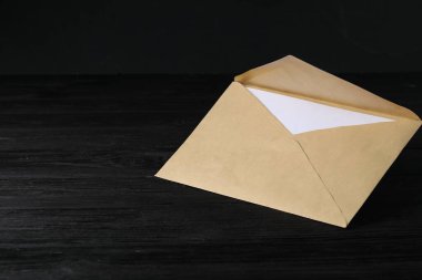 Siyah ahşap masa üzerinde mektup olan Kraft kağıt zarf. Tasarım için model