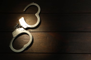 Ahşap masada metal zincir kelepçeler, üst manzara. Metin için boşluk