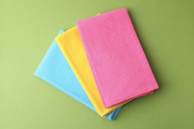 Yeşil arka planda farklı mikrofiber kumaşlar, üst görünüm