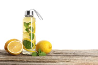 Şişe içinde naneli limon suyu ve beyaz arka planda tahta masada taze meyveler. Metin için boşluk