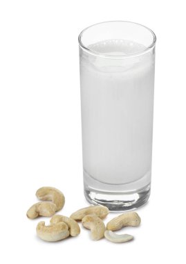 Bardakta taze kaju sütü ve beyaz üzerine izole edilmiş fındık.