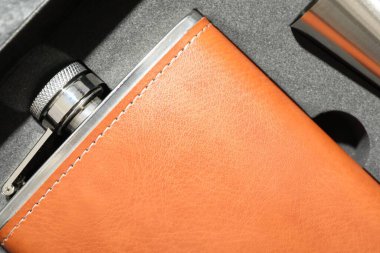 Kalça matarası ve bardak pakette, üst görünümde.