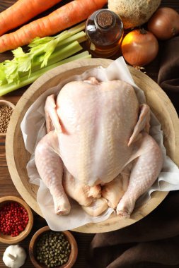 Tabakta taze çiğ hindi ve masada farklı ürünler var.