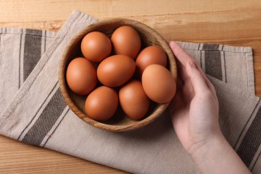 Ahşap masadaki çiğ yumurtalı kadın.