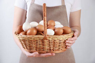 Hafif arka planda yumurta sepeti olan kadın, yakın plan.