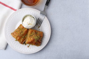 Gri masada servis edilen ezilmiş fındıklı ve dondurmalı enfes baklava. Metin için boşluk