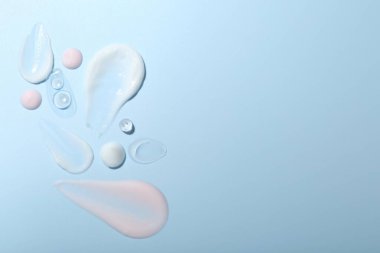 Açık mavi arka planda krema ve jel örnekleri, üst manzara. Metin için boşluk