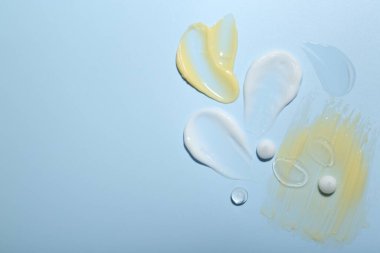 Açık mavi arka planda krema ve jel örnekleri, üst manzara. Metin için boşluk