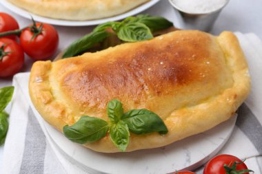 Fesleğen ve domatesli leziz vejetaryen calzone, yakın plan.