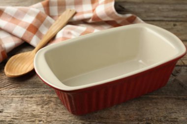 Seramik güveç ve kaşık ahşap masada, yakın plan.