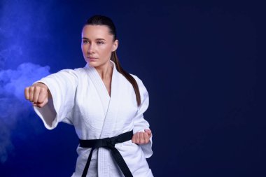 Koyu mavi arka planda kimonolu karate dövüşçüsü, metin için boşluk