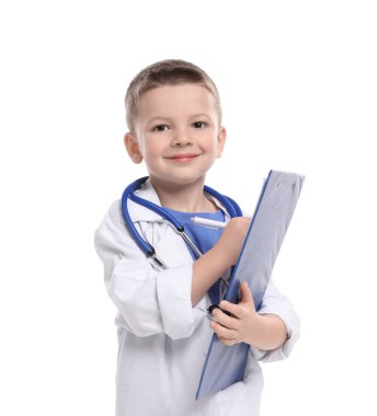 Stetoskop ve not panosuyla beyaz arka planda doktor gibi davranan küçük bir çocuk. Geleceğin mesleğini hayal etmek