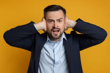 Man covering his ears on orange background clipart